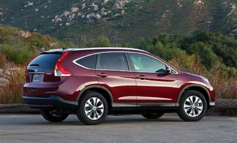 A Red Honda Cr V Parked In Front Of A Mountain