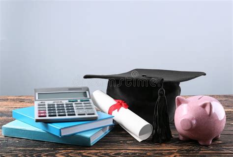 Mortar Board Books Calculator Diploma And Piggy Bank On Table Fee