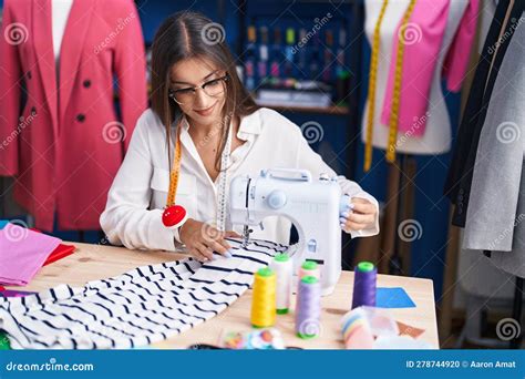 Young Beautiful Hispanic Woman Tailor Smiling Confident Using Sewing