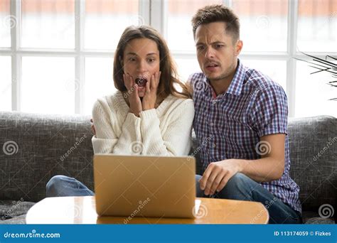 Shocked Couple Confused And Scared Watching Horror Movie On Laptop