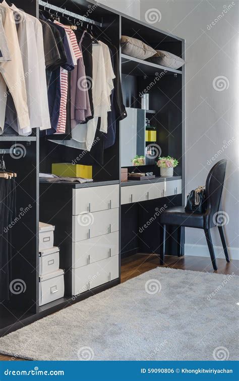 Dark Color Scheme Modern Walk In Closet Design With Black Chair Stock