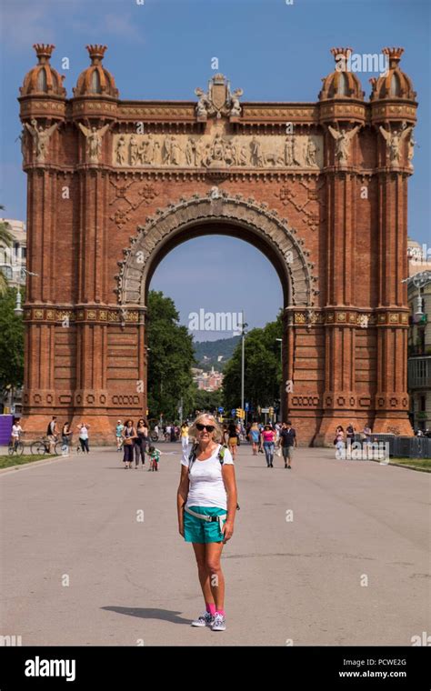 Woman Tourist Poses For A Photograph In Front Of The Red Brickwork Of