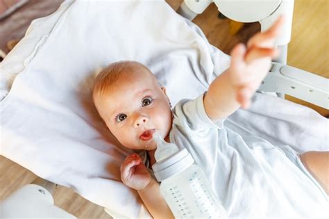 Mignonne Petite Fille Nouveau Née Buvant Du Lait De La Bouteille Et