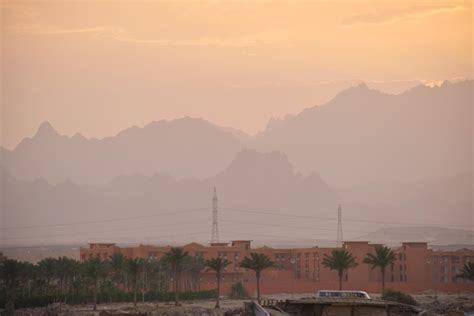 Paisaje Al Atardecer Con Complejo Hotelero Remoto Contra Picos