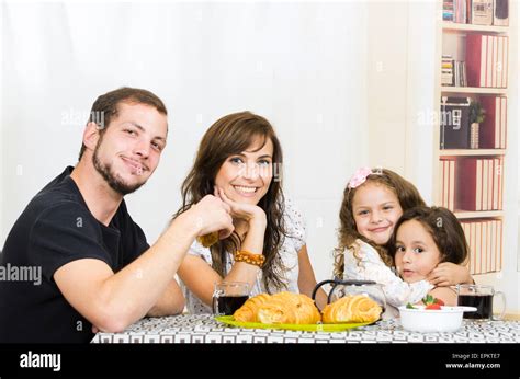 Beautiful young happy family eating meal Stock Photo - Alamy