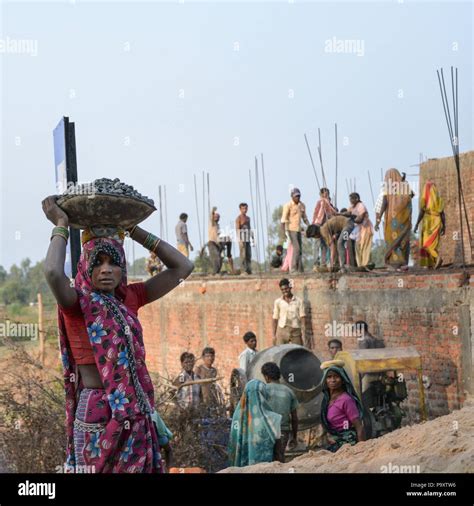 A lifestyle photo of an Indian woman carrying a basket on her head with ...