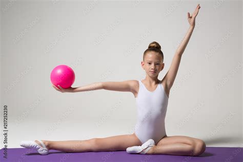 Young gymnast doing an exercise with a ball. Children's sports. Children's gymnastics. Girl ...