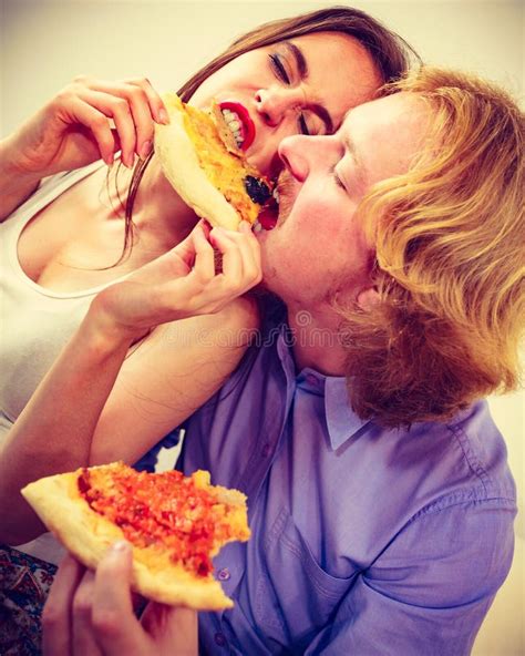 Pares Divertidos Que Comen La Pizza Foto De Archivo Imagen De Lazo