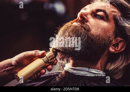 Handsome hipster man client visiting haidresser and hairstylist in barber shop Stock Photo - Alamy