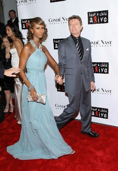 a man in a suit and woman in a blue dress walking down the red carpet