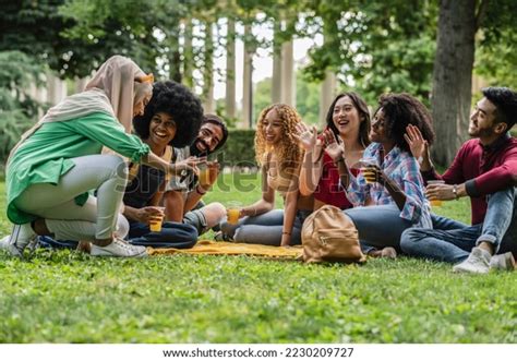 Multiracial Group Friends Sitting On Grass Stock Photo 2230209727