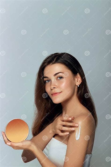 Beauty Concept Woman Holds A Cosmetic Crem In Her Hand And Spreads It