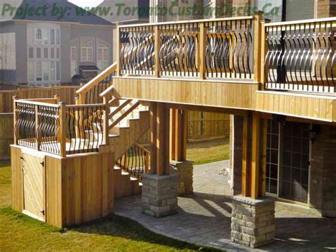 A Wooden Deck With Railings And Stone Pillars