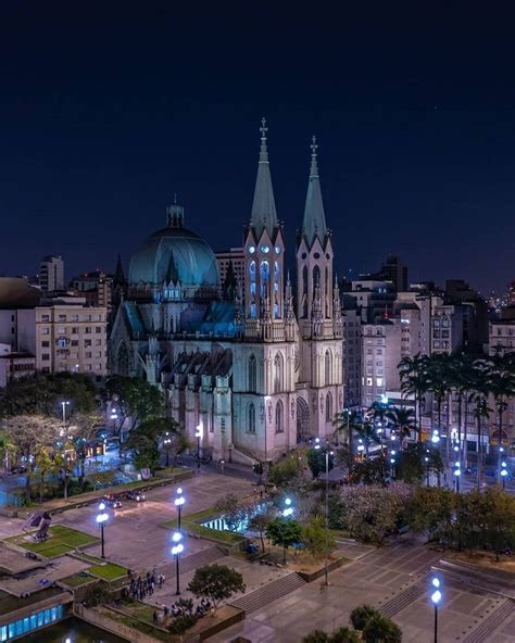 A Large Cathedral Lit Up At Night With Lights On It S Sides And Tall Spires