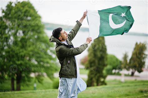 Traditional clothes indian pakistani male portrait hold Pakistan flag