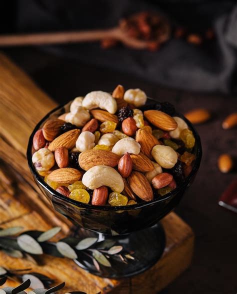 Recipiente con frutos secos orgánicos mixtos sobre tabla de madera