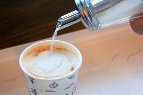 Premium Photo Close Up Of Throwing Sugar Into Hot Cappuccino In Coffee Shop