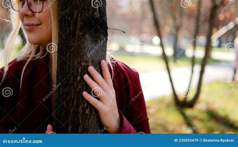 Cute Blonde Hugs A Tree In The Autumn City Park Beautiful Woman Gently Hugs A Tree Trunk In The