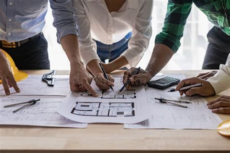 Engineer Pointing At Blueprint And Using Laptop To Draw Project Design