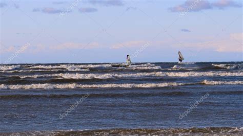 Surfista profesional en el viento preparando el viento en el mar al océano. Windsurfer atrapa la ...