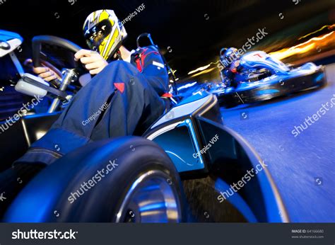 Two Go-Cart Drivers Battling In A Competitive Race On An Indoor Circuit ...