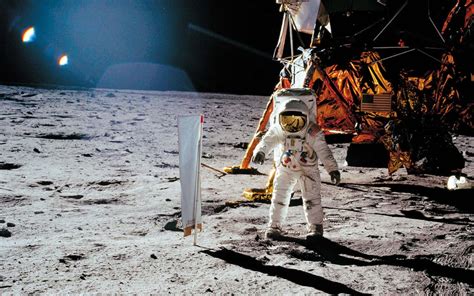 Download A Man In A Space Suit Standing On The Moon | Wallpapers.com