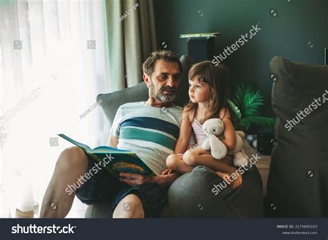 Grandfather Reading Book His Granddaughter Sitting Stock Photo