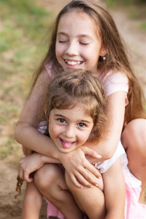 Deux Belles Petites Filles Embrassant Et Riant Du Bord De La Mer Photo