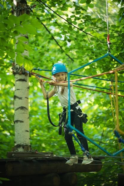 Aventura de cuerda extrema en el bosque una niña camina en el puente de