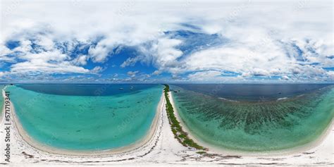 Panoramic view of one of the atolls in the Maldives from a bird's eye view. A thin strip of land ...