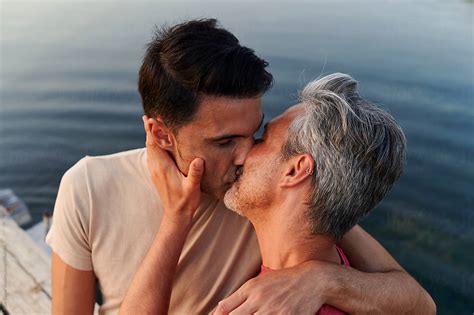 Gay Couple Kissing On A Pier Over Water By Stocksy Contributor Ivan