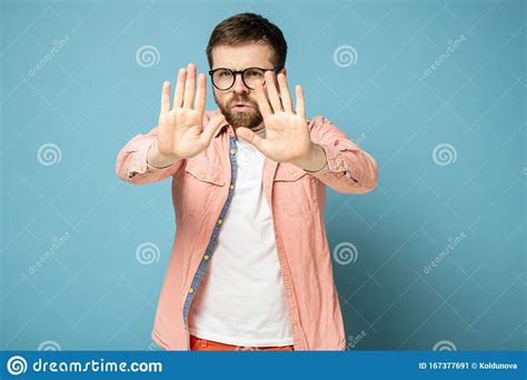 Confident Bearded Man In Glasses With Palm Makes A Stop Sign A Gesture