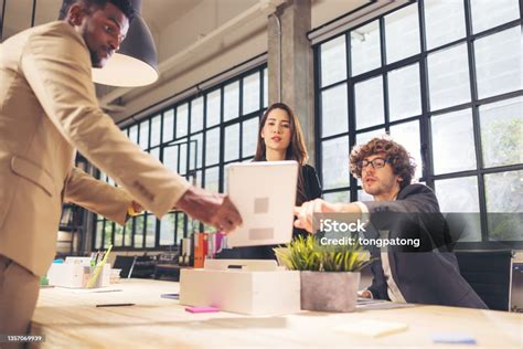 Colleagues In A Boardroom Discussion Seated At A Table Together