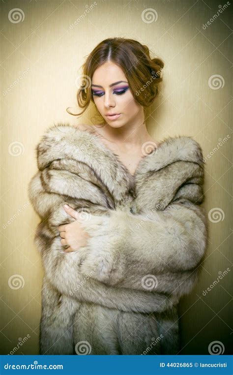 Attractive Young Woman Wearing A Fur Coat Posing Provocatively Indoor