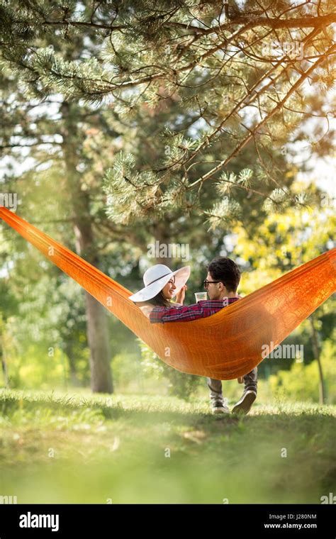 Romantic Couple In Hammock Photographed From Behind In Forest Stock