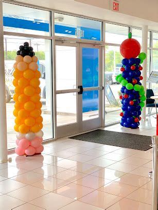 Balloons Are Hanging From The Ceiling In An Open Room With White Tile