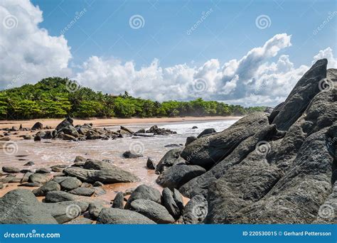 Pedras Escuras Negras Deitadas Numa Praia Depois Da Costa Imagem De