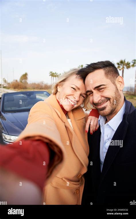 Vertical Happy Middle Aged Couple Take Selfie Outside Car Wife And