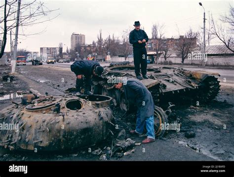 First Chechen War, November 1994. Civilians look at a destroyed Russian ...