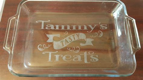 A Glass Tray With The Words Tasty Treats Written In White Ink On It Sitting On A Wooden Table