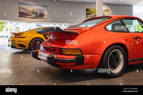 A picture of a red Porsche 911 Carrera 3.0 next to an orange Porsche 911 Turbo S inside a ...