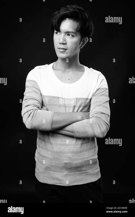 Young Handsome Asian Man Thinking Against Black Background Stock Photo