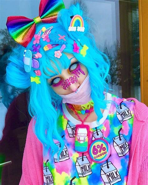 a woman with blue hair wearing a colorful wig and tie dye makeup on her ...