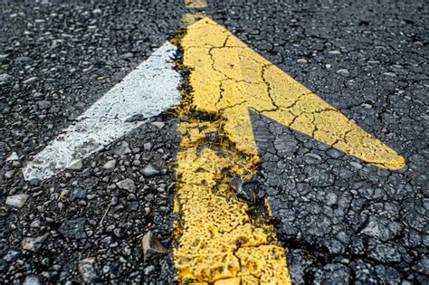 A Yellow Arrow Painted On The Side Of A Road Suitable For