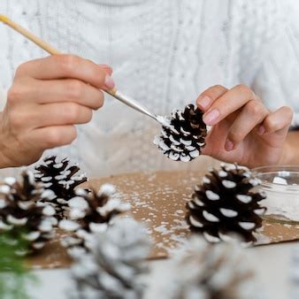 Free Photo | Person painting pine cones for christmas