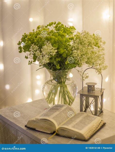 Composition An Open Bible A Bouquet Of Wildflowers In A Vase And A