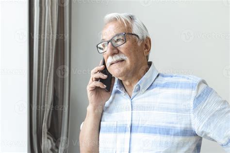 hombre mayor en casa hablando por teléfono celular hombre alegre