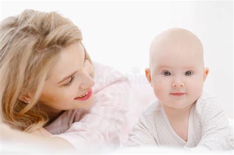 La Jeune Belle Mère Blonde Du Caucase Se Trouve Sur Le Lit Avec Sa