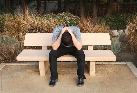 Man Sitting On Bench With Head Down Del Colaborador De Stocksy Dina