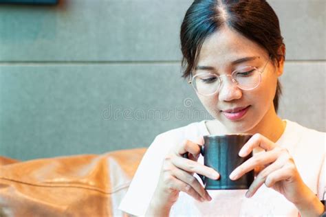 Portrait Of An Asian Woman With A Black Cup Of Aromatic Coffee Or Tea